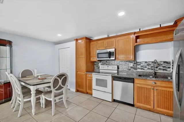 a kitchen with stainless steel appliances granite countertop a refrigerator and a sink