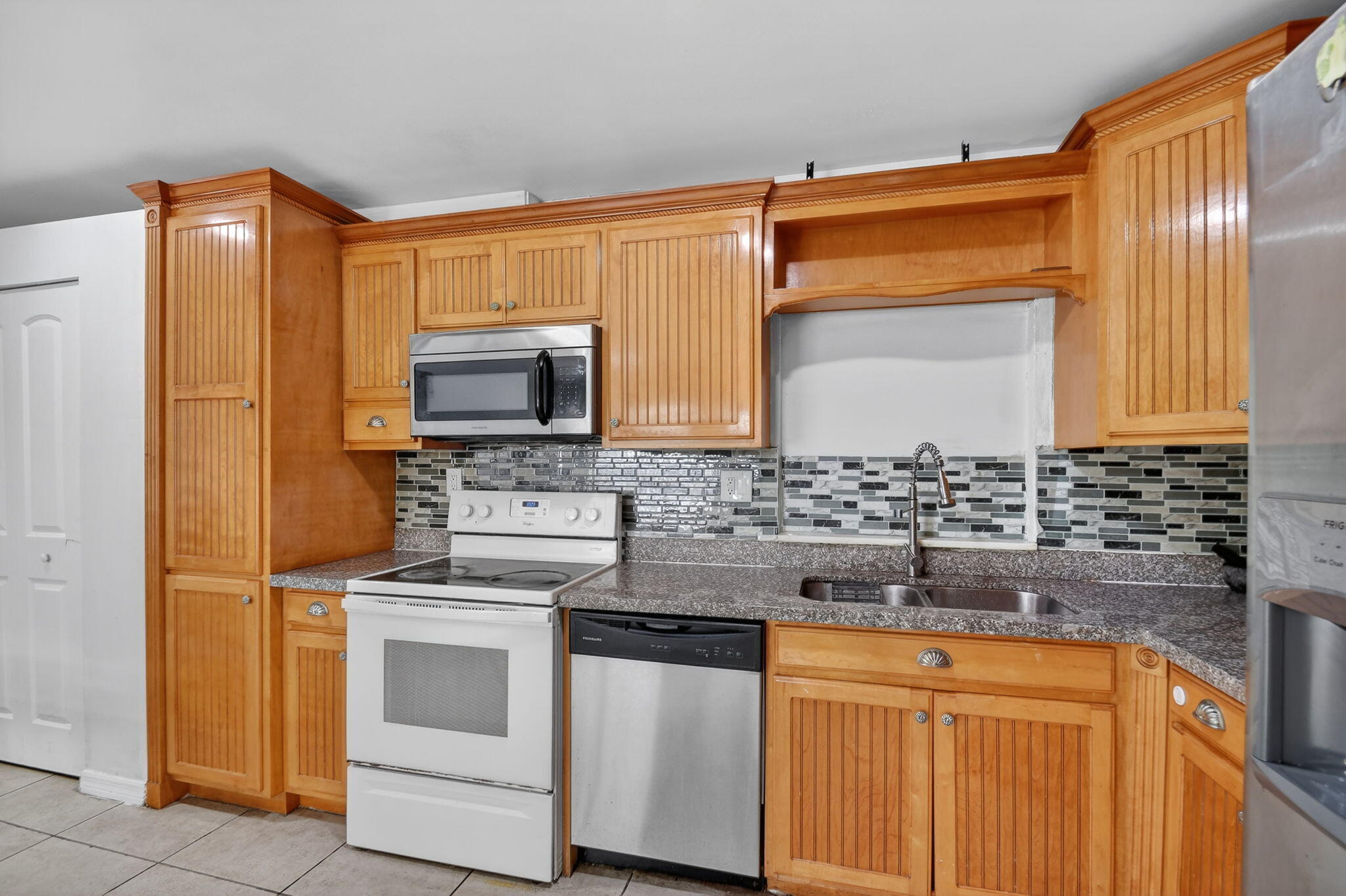 4559 Cole Street West Palm Beach, FL 33417 - Photo 18 of 72 a kitchen with stainless steel appliances granite countertop a stove a sink and a microwave