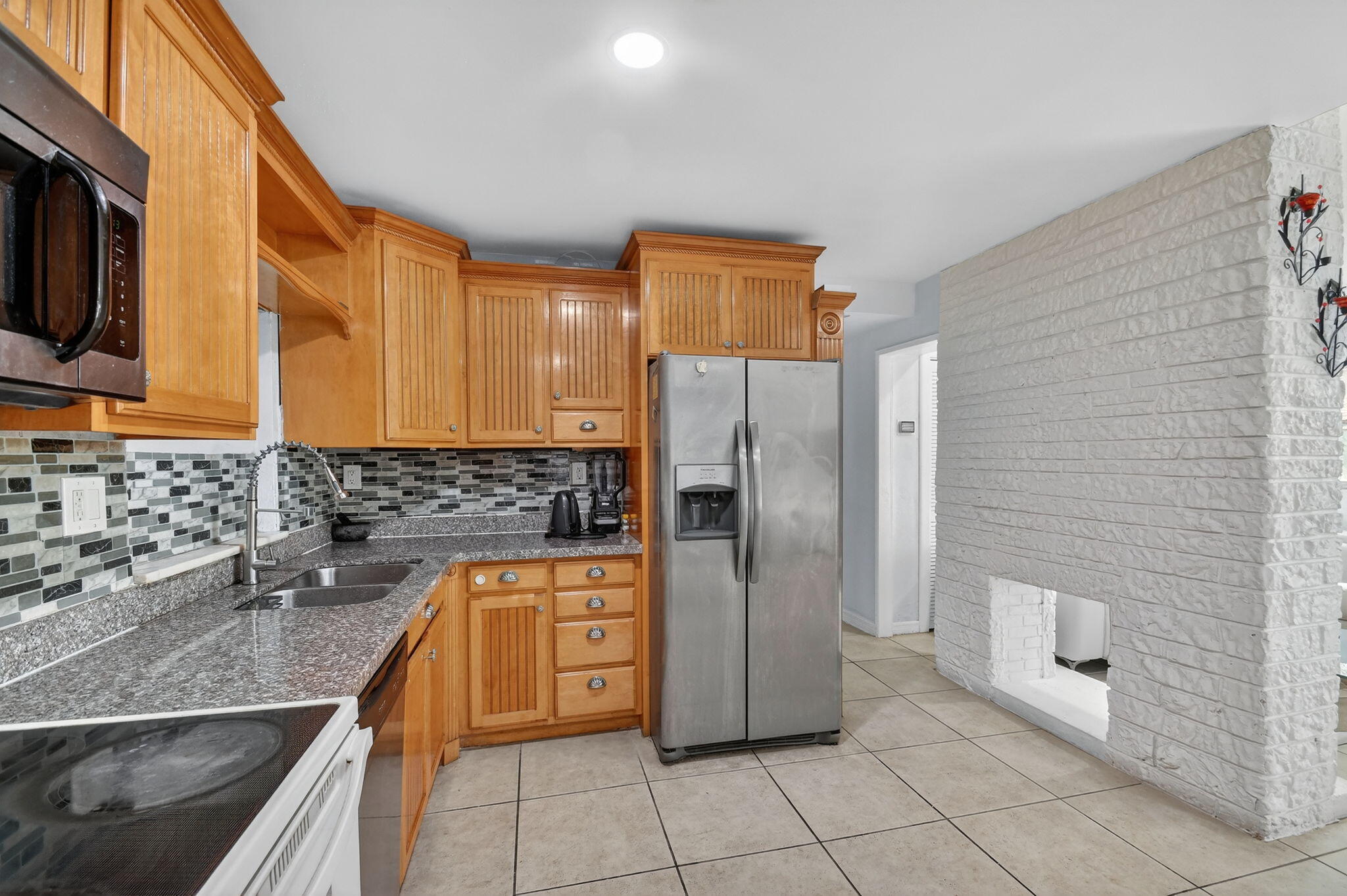 4559 Cole Street West Palm Beach, FL 33417 - Photo 20 of 72 a kitchen with stainless steel appliances granite countertop a refrigerator and a sink