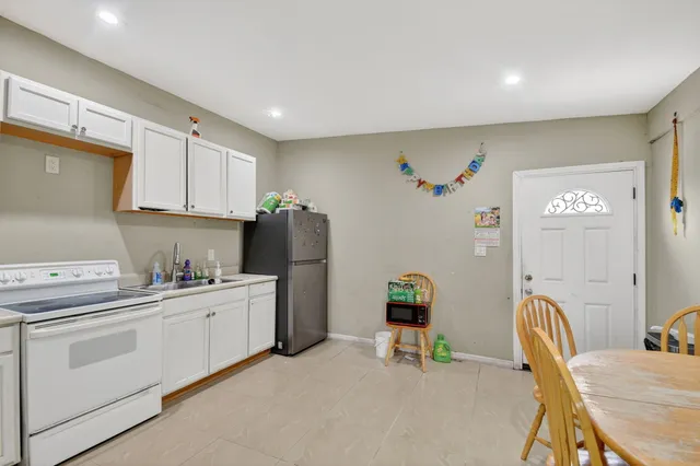 a view of a backyard with plants and a large tree