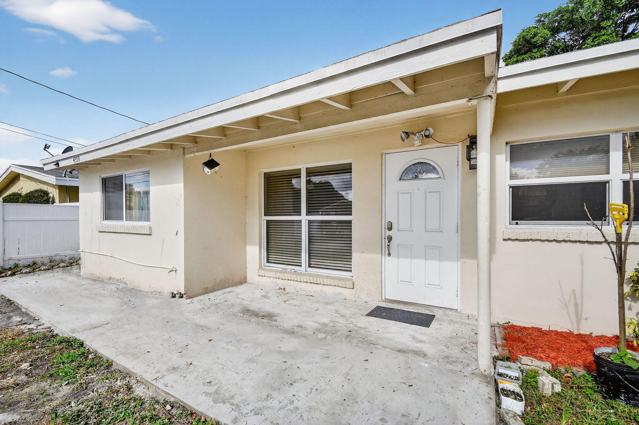 4559 Cole Street West Palm Beach, FL 33417 - Photo 6 of 72 a front view of a house with a large window and potted plants