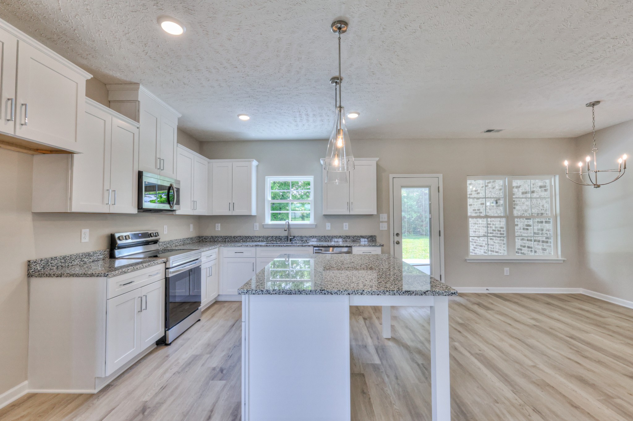 1234 North Fork Branch Road Normandy, TN 37360 - Photo 9 of 38 a large kitchen with stainless steel appliances kitchen island granite countertop a stove a sink a refrigerator and white cabinets with wooden floor