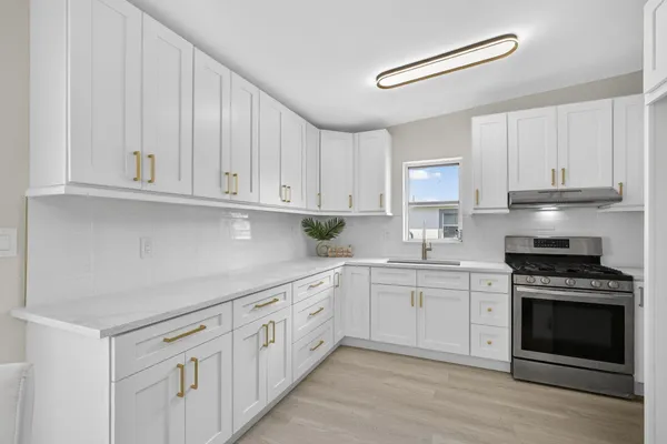 a kitchen with granite countertop white cabinets and stainless steel appliances