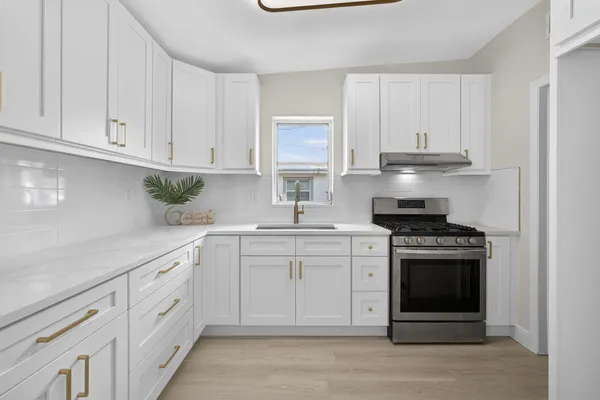 a kitchen with white cabinets and appliances