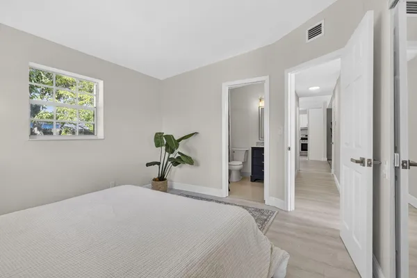 a bedroom with a bed and a painting on the wall