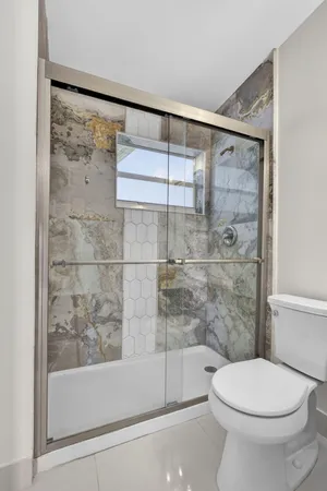 a bathroom with a toilet and a shower