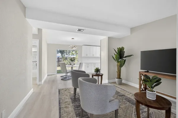 a living room with furniture a large window and a flat screen tv