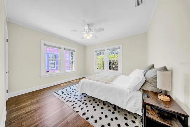 a bedroom with a bed and wooden floor