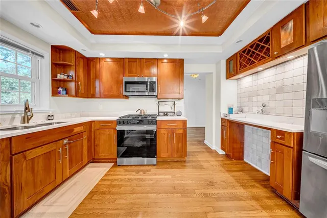 a large kitchen with stainless steel appliances granite countertop a stove a sink and a refrigerator