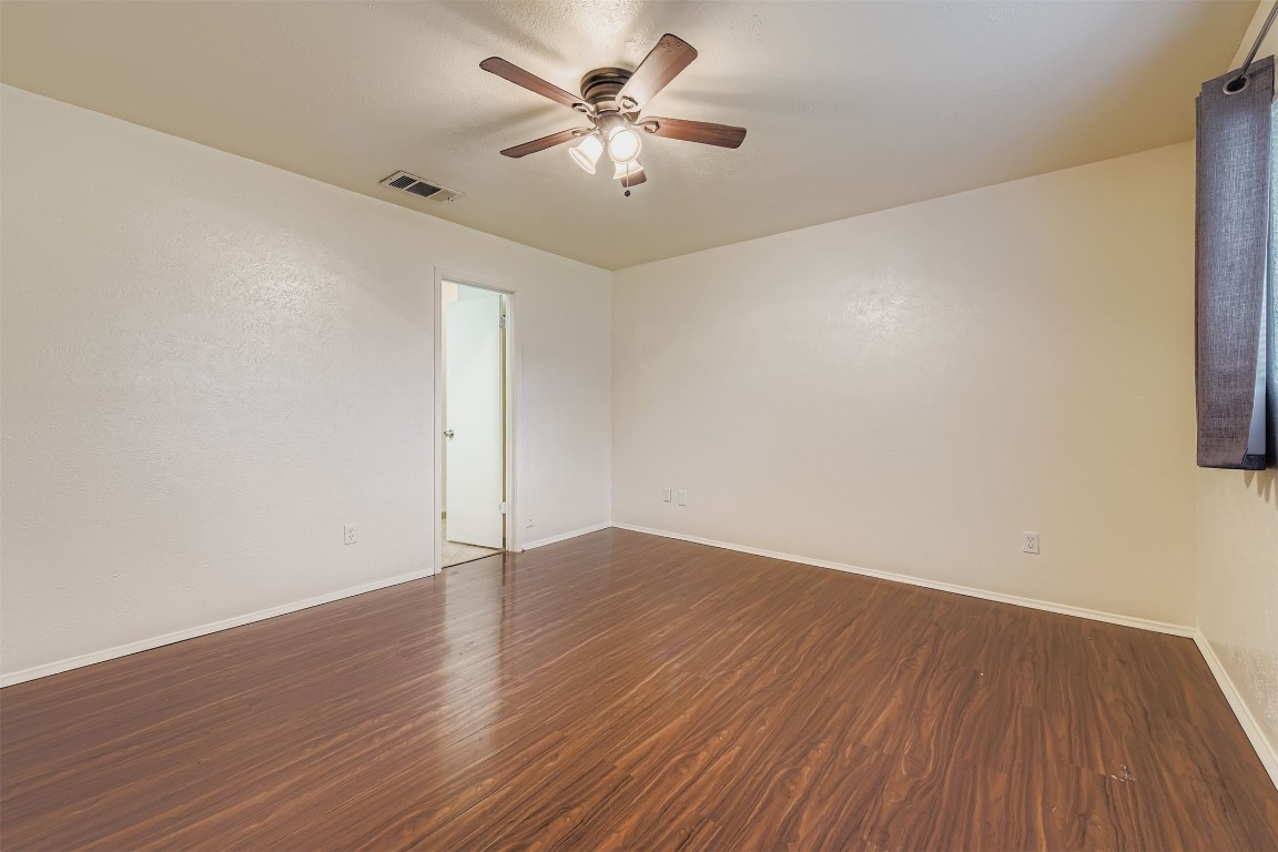 3104 Dominic Drive Austin, TX 78745 - Photo 15 of 28 Empty room with dark wood-style flooring and ceiling fan