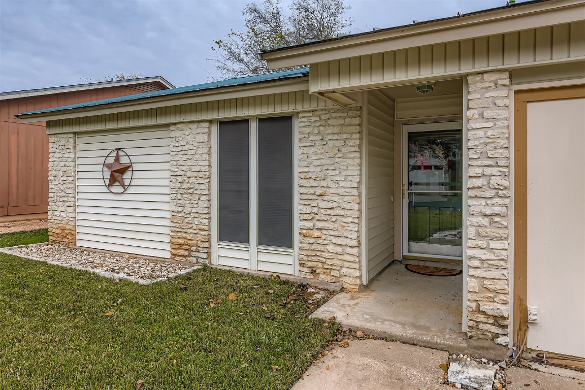 3104 Dominic Drive Austin, TX 78745 - Photo 4 of 28 Doorway to property featuring stone siding and a lawn