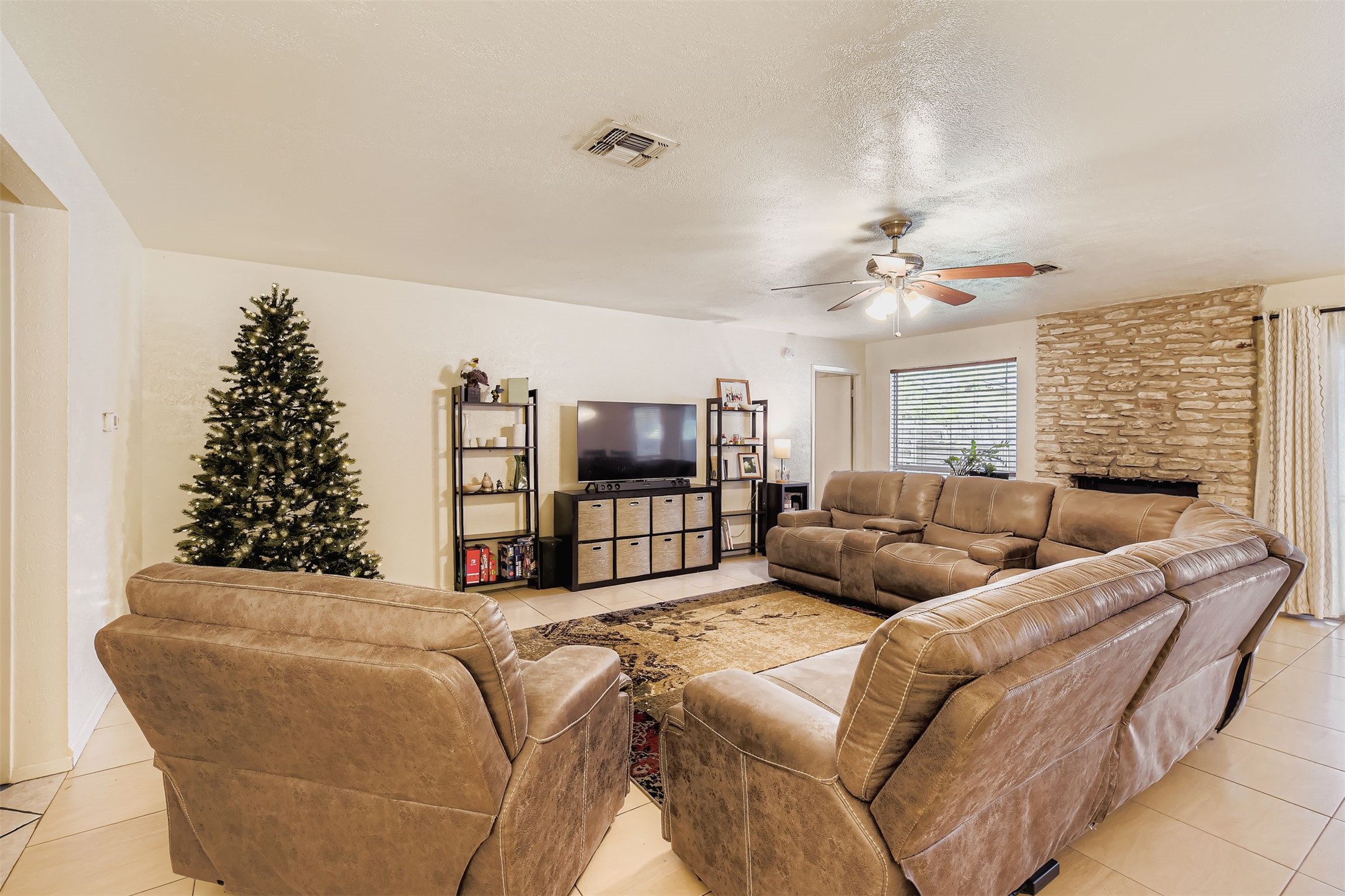 3104 Dominic Drive Austin, TX 78745 - Photo 6 of 28 Living area with light tile patterned flooring, a textured ceiling, ceiling fan, and a fireplace