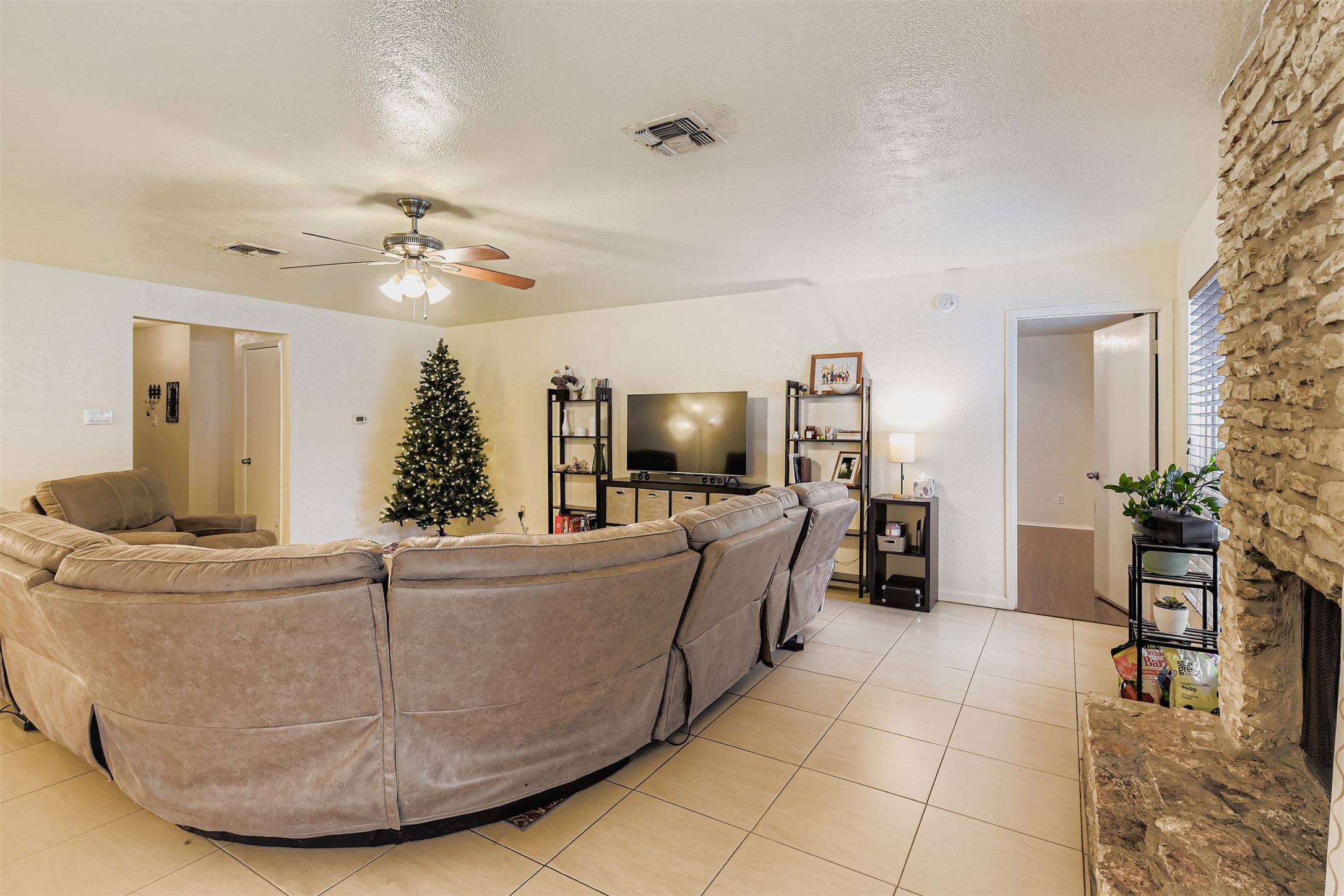 3104 Dominic Drive Austin, TX 78745 - Photo 7 of 28 Living area with a textured ceiling, ceiling fan, and light tile patterned flooring