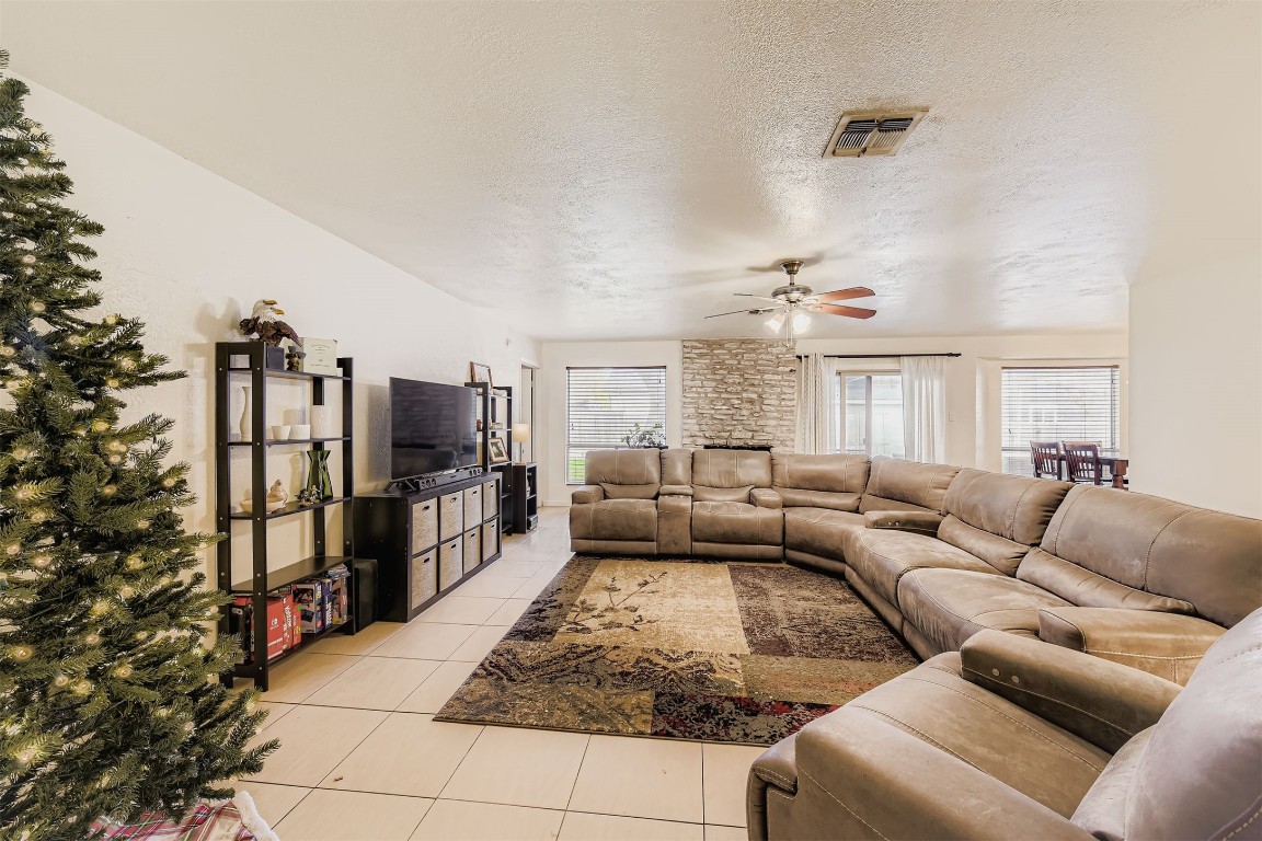 3104 Dominic Drive Austin, TX 78745 - Photo 9 of 28 Living area with a textured ceiling, light tile patterned floors, and ceiling fan