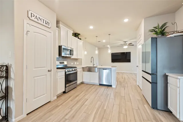 a kitchen with stainless steel appliances a refrigerator sink and microwave