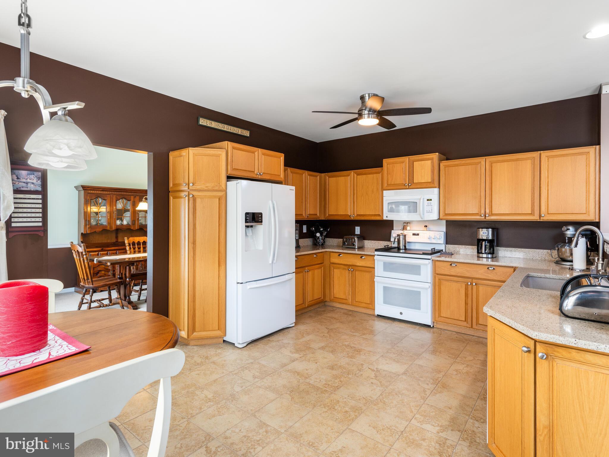 105 Hydrangea Way Coatesville, PA 19320 - Photo 11 of 26 a kitchen with stainless steel appliances kitchen island granite countertop a refrigerator stove top oven and sink