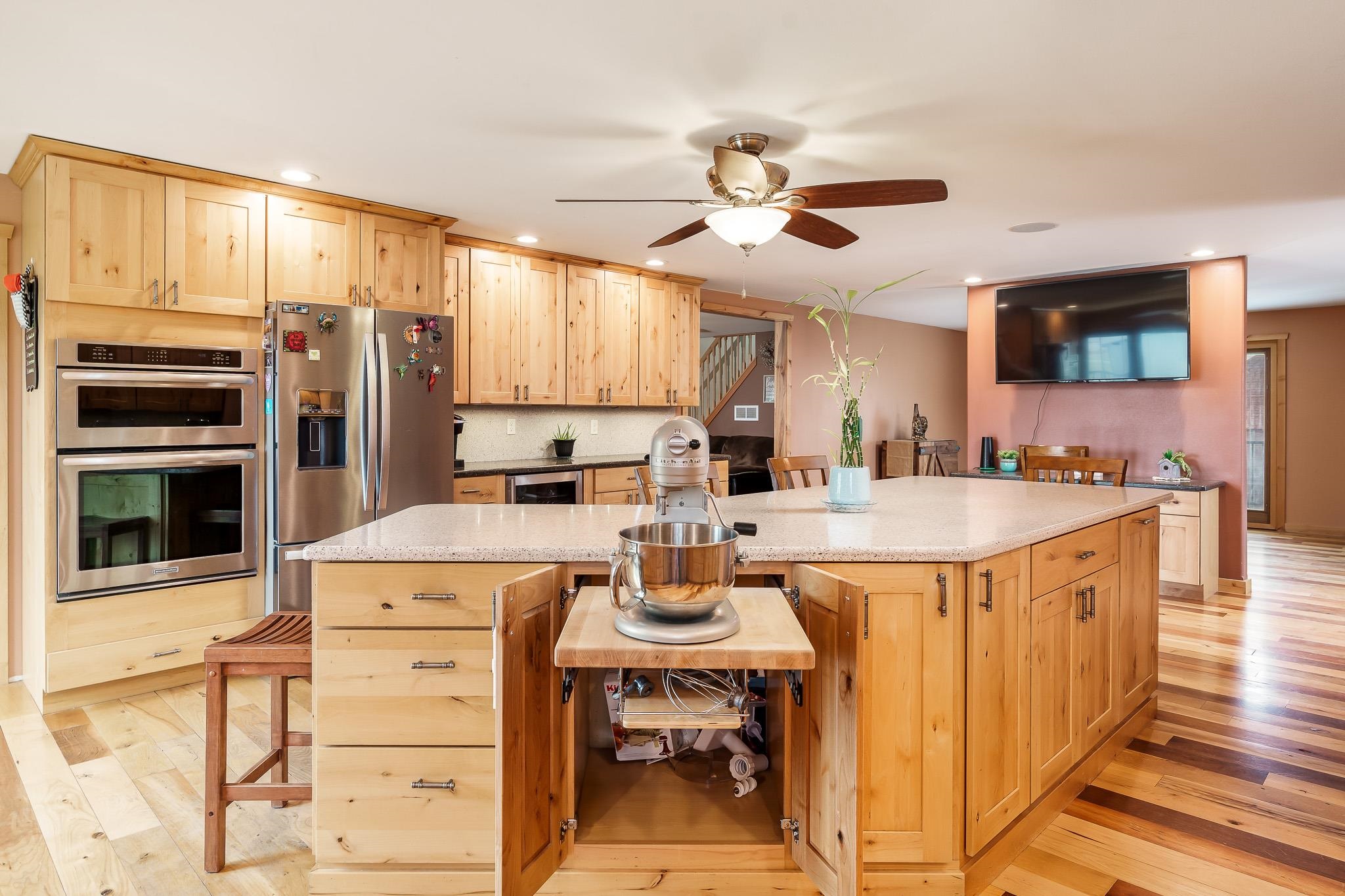 10760 East Rock Grove Road Davis, IL 61019 - Photo 59 of 91 a kitchen with stainless steel appliances kitchen island granite countertop a table chairs in it and wooden floors