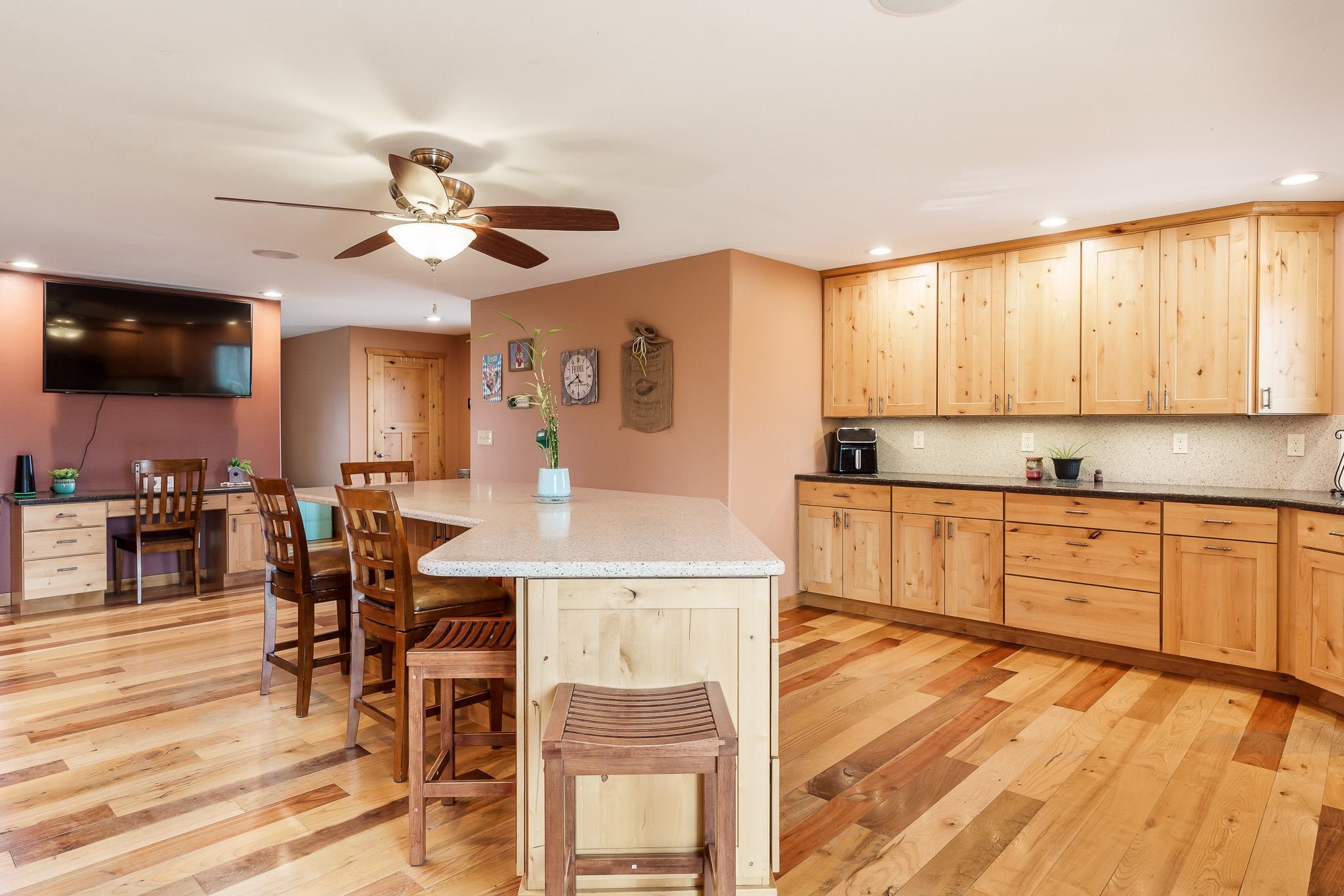 10760 East Rock Grove Road Davis, IL 61019 - Photo 61 of 91 a kitchen with stainless steel appliances kitchen island granite countertop a stove top oven a sink a dining table and chairs with wooden floor