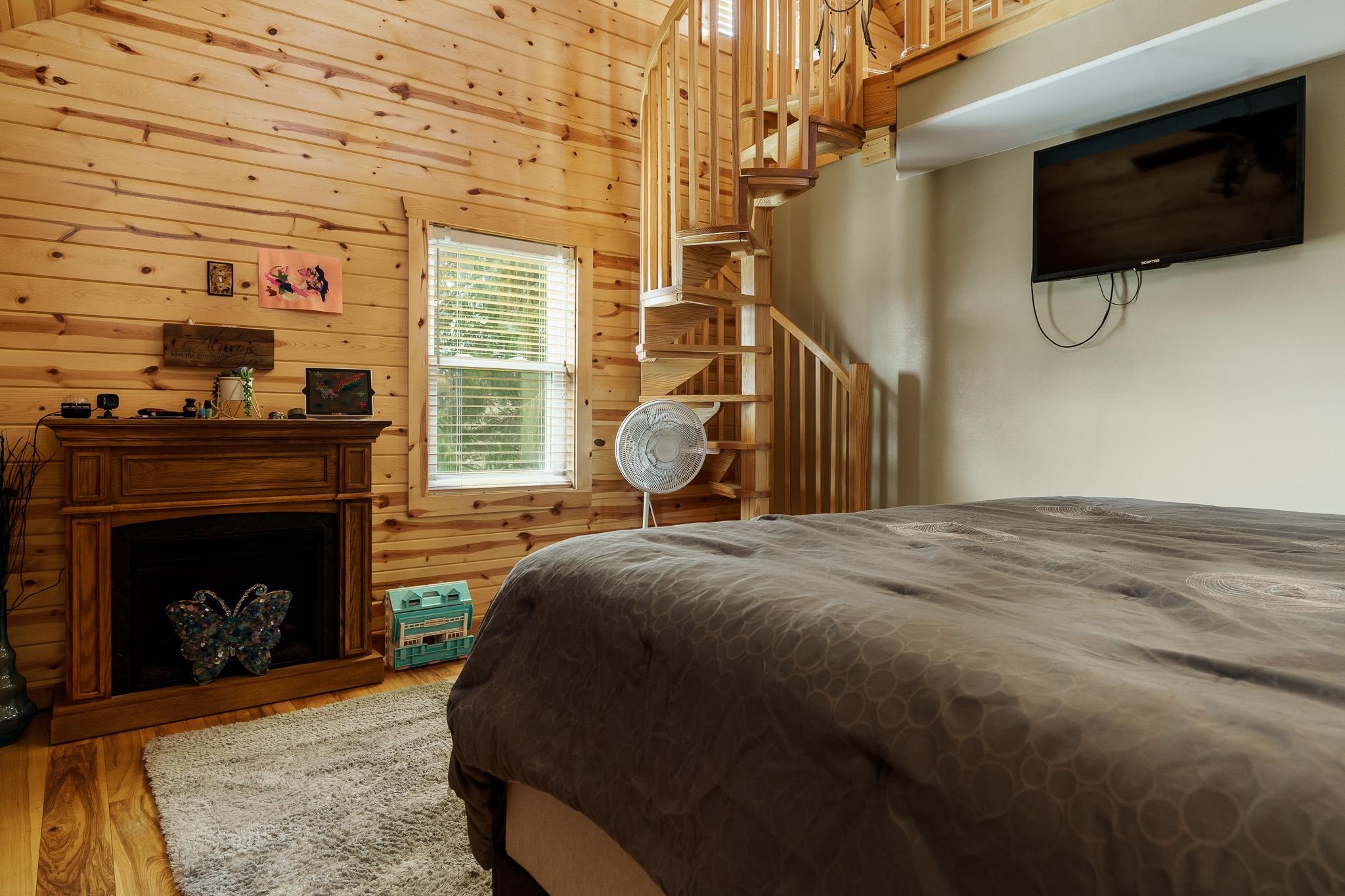 10760 East Rock Grove Road Davis, IL 61019 - Photo 77 of 91 a bedroom with a bed a fireplace and a television