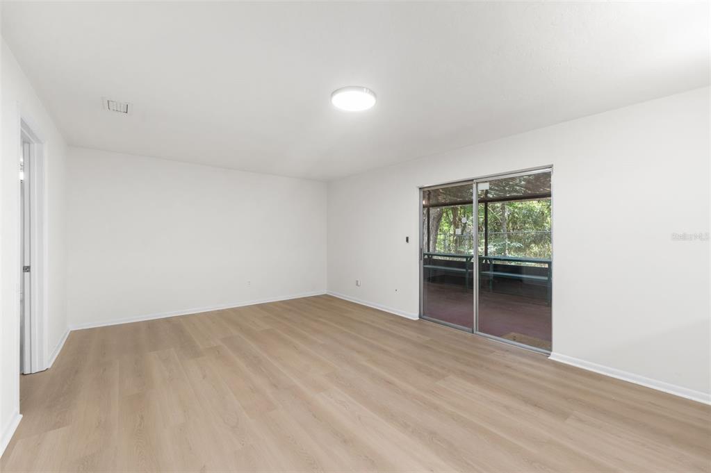 4825 Southwest 19th Street Gainesville, FL 32608 - Photo 6 of 40 a view of an empty room with wooden floor and a window