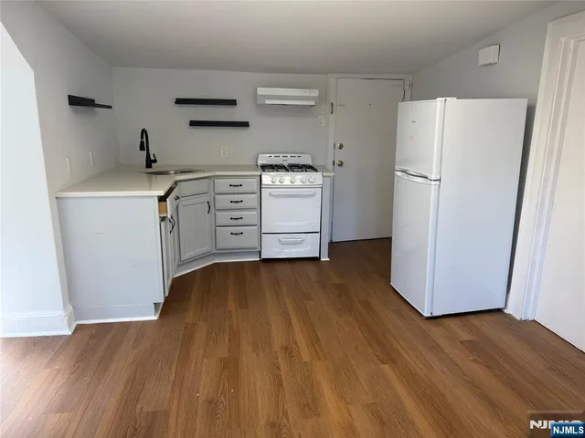 a kitchen with a refrigerator and a stove top oven