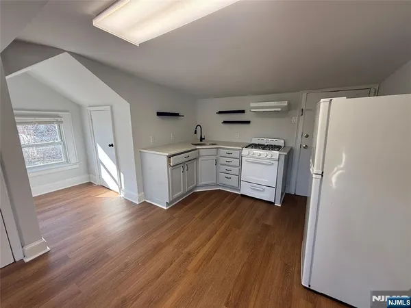 a kitchen with cabinets and wooden floor