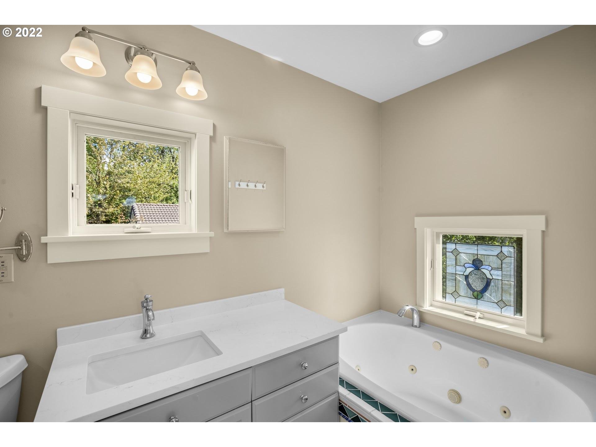 14440 Northwest McNamee Road Portland, OR 97231 - Photo 18 of 32 a bathroom with a sink a mirror and a window