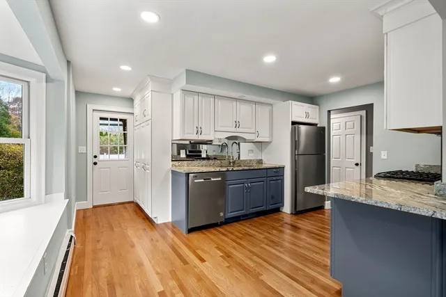 a kitchen with granite countertop a refrigerator and a stove top oven