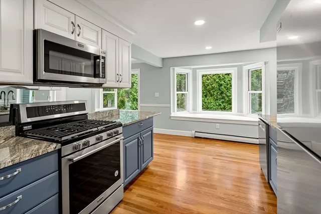 a kitchen with a stove a microwave and windows