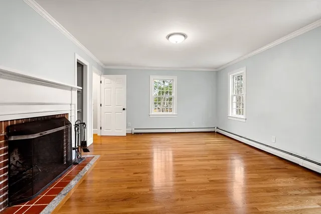 a view of an empty room with a fireplace and a window