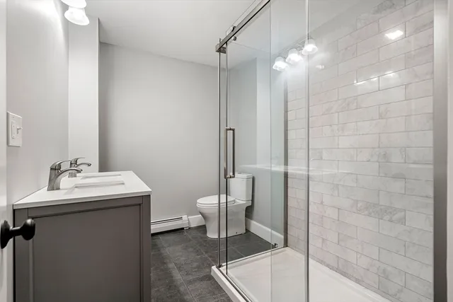 a bathroom with a sink a toilet and shower