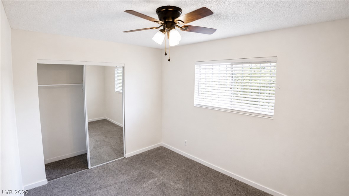 2870 South Sandhill Road Las Vegas, NV 89121 - Photo 62 of 64 A well-lit bedroom provides comfort and style, with plush carpet and a convenient closet.