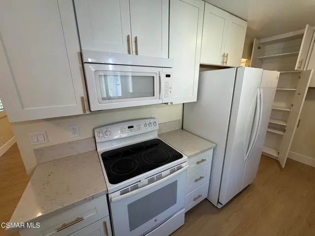 a kitchen with white cabinets and stainless steel appliances