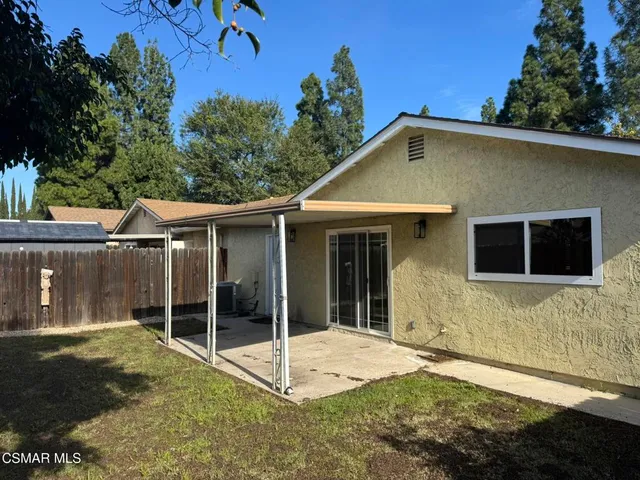 a view of a house with a backyard and a tree