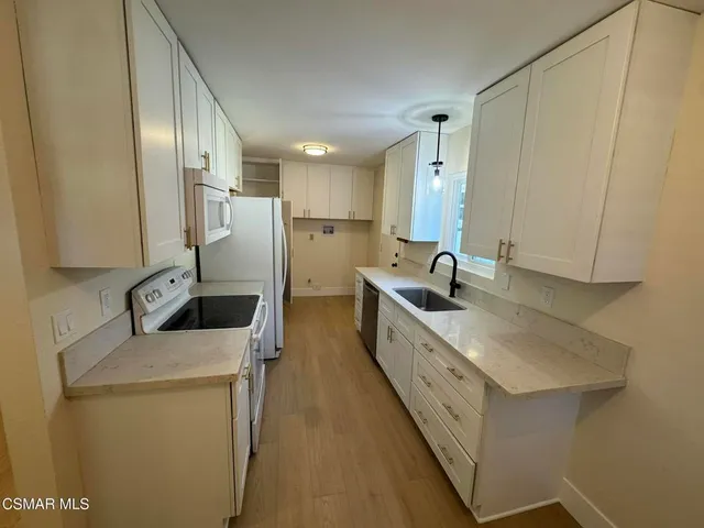 a kitchen with sink a refrigerator and cabinets