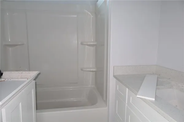 a bathroom with a tub sink and vanity