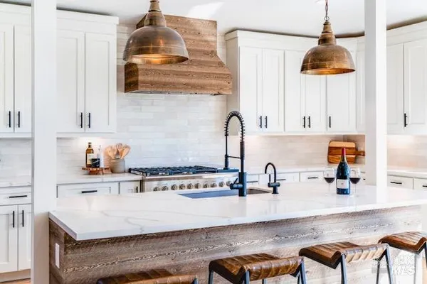 a kitchen with stainless steel appliances granite countertop a sink a stove and a wooden cabinets