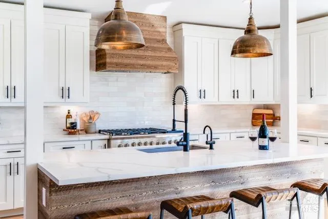 a kitchen with stainless steel appliances granite countertop a sink a stove and a wooden cabinets