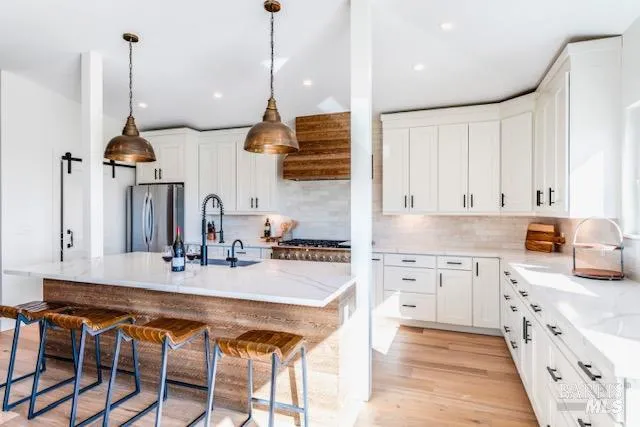 a kitchen with kitchen island granite countertop a sink a stove and a wooden floors