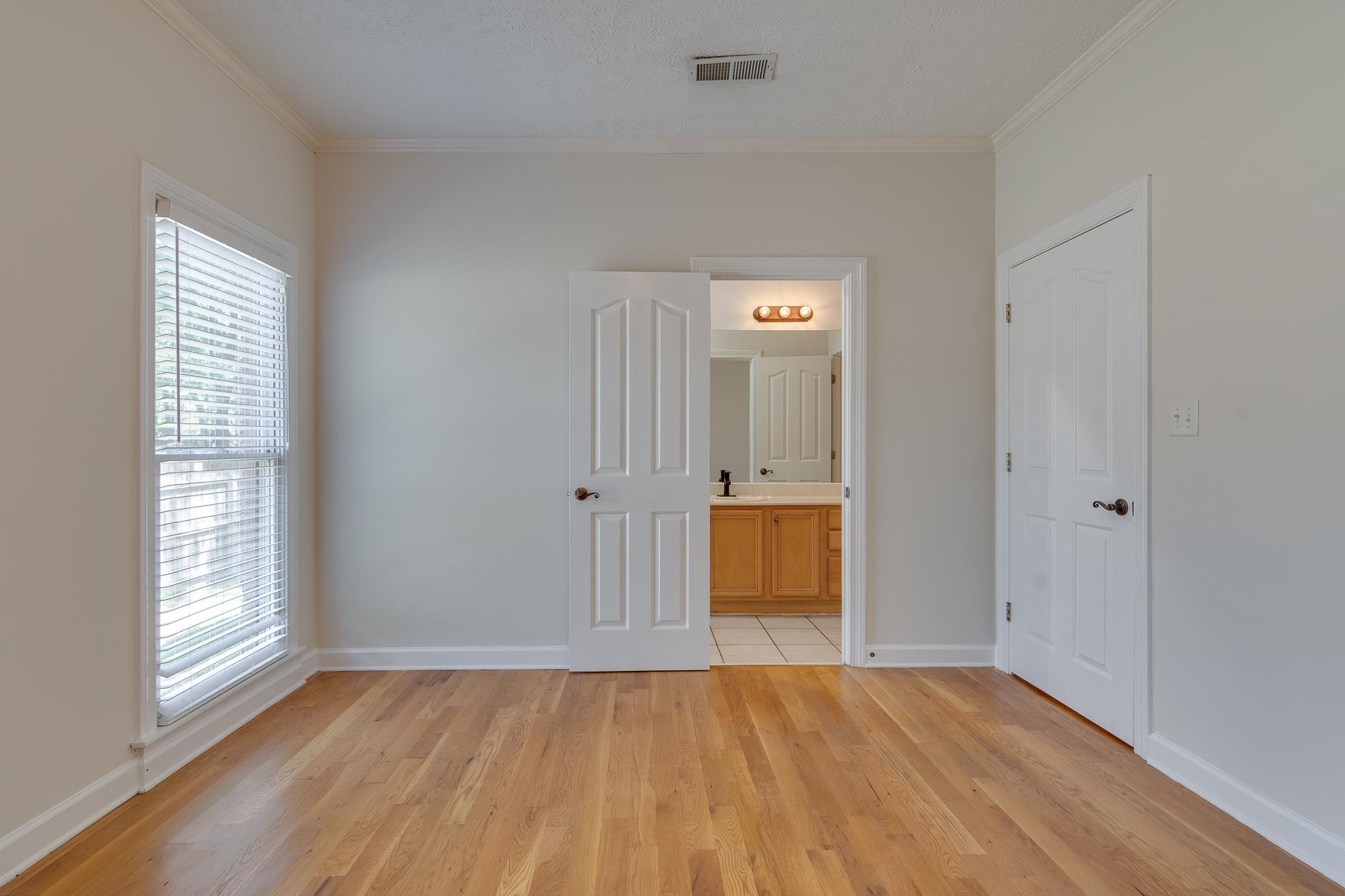 4306 Wind Tree Cove Bartlett, TN 38135 - Photo 15 of 28 an empty room with wooden floor and windows