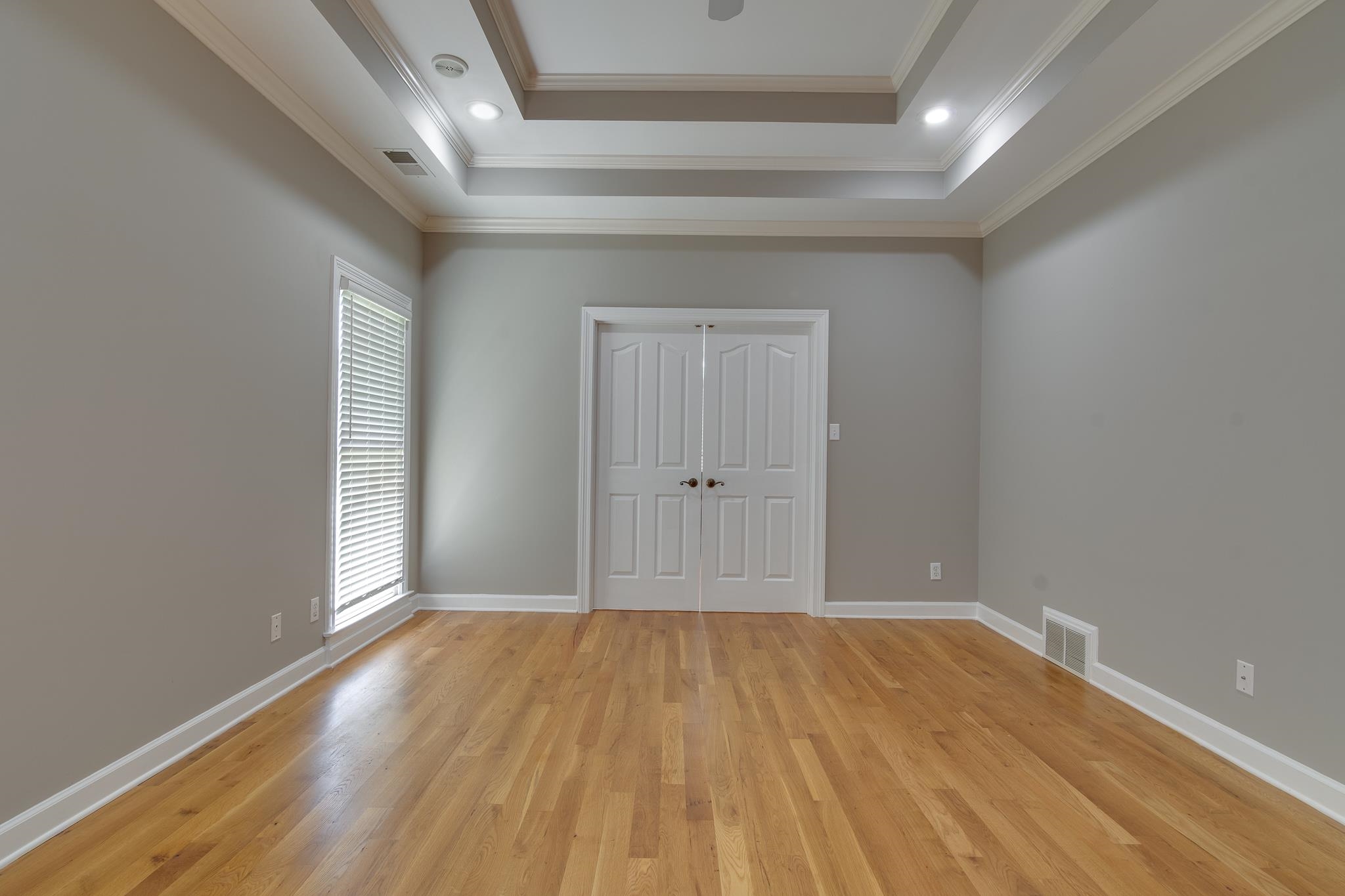 4306 Wind Tree Cove Bartlett, TN 38135 - Photo 18 of 28 an empty room with wooden floor and windows