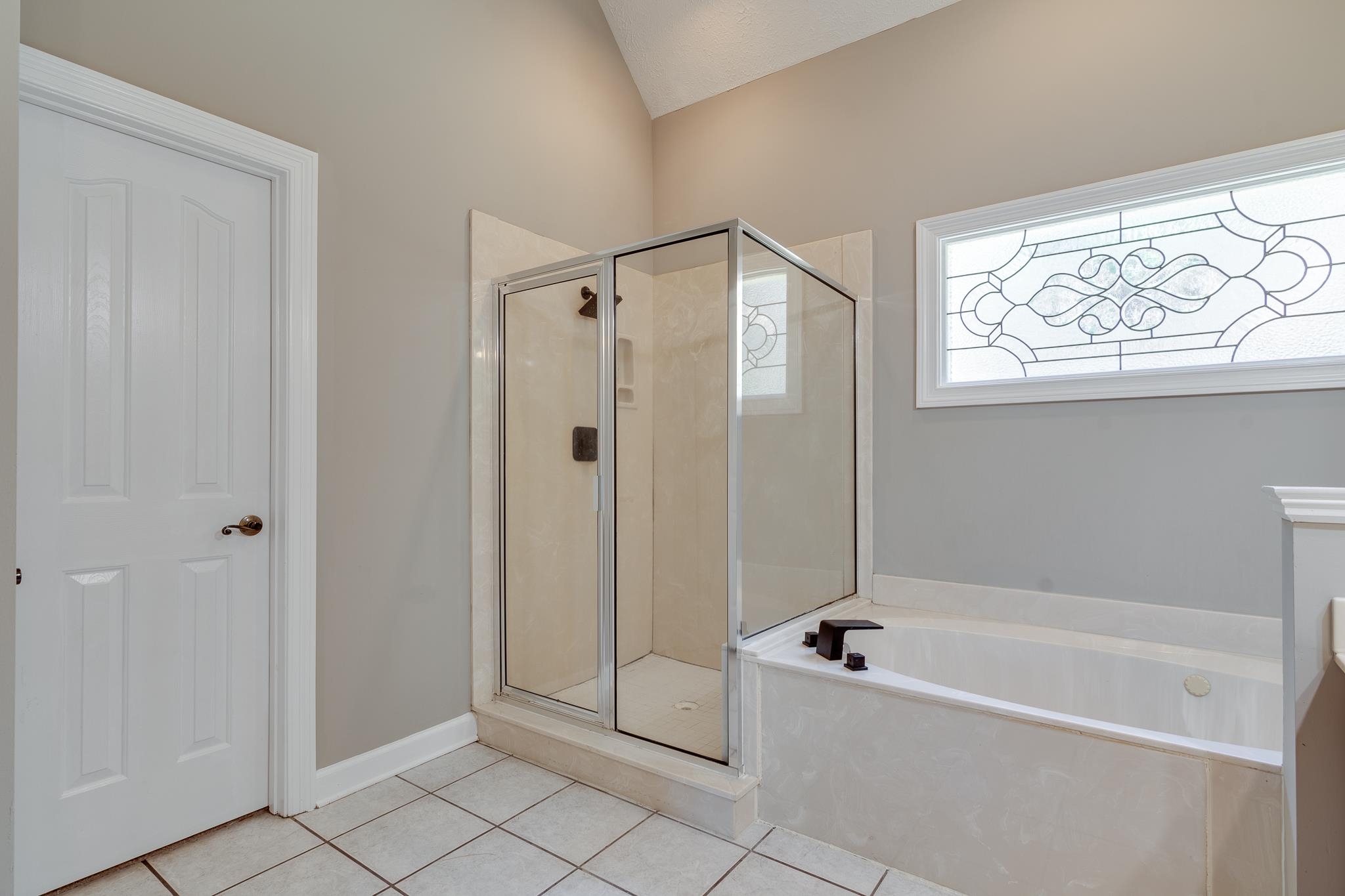 4306 Wind Tree Cove Bartlett, TN 38135 - Photo 22 of 28 a bathroom with a tub shower and window