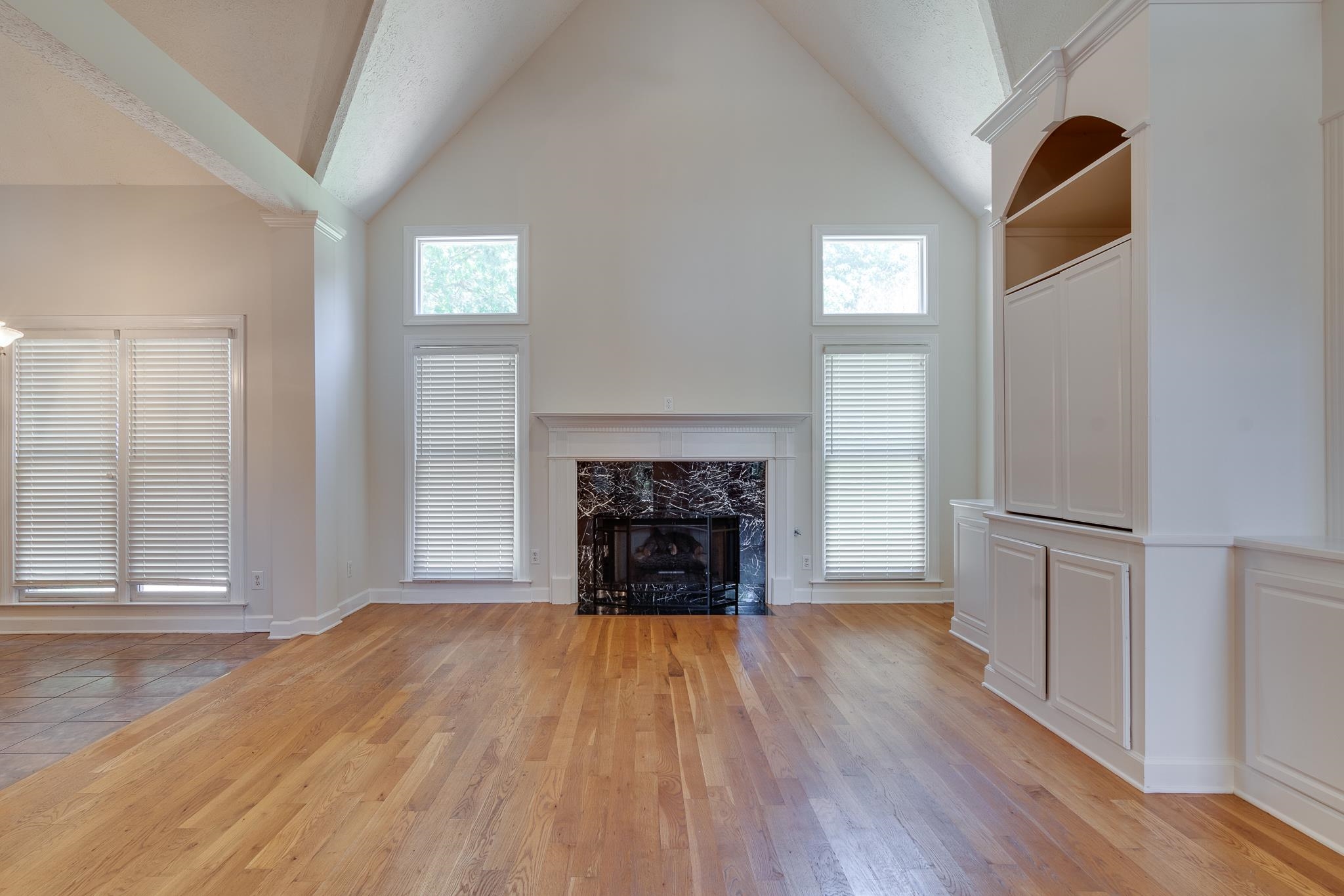 4306 Wind Tree Cove Bartlett, TN 38135 - Photo 6 of 28 a view of a livingroom with wooden floor a fireplace and windows
