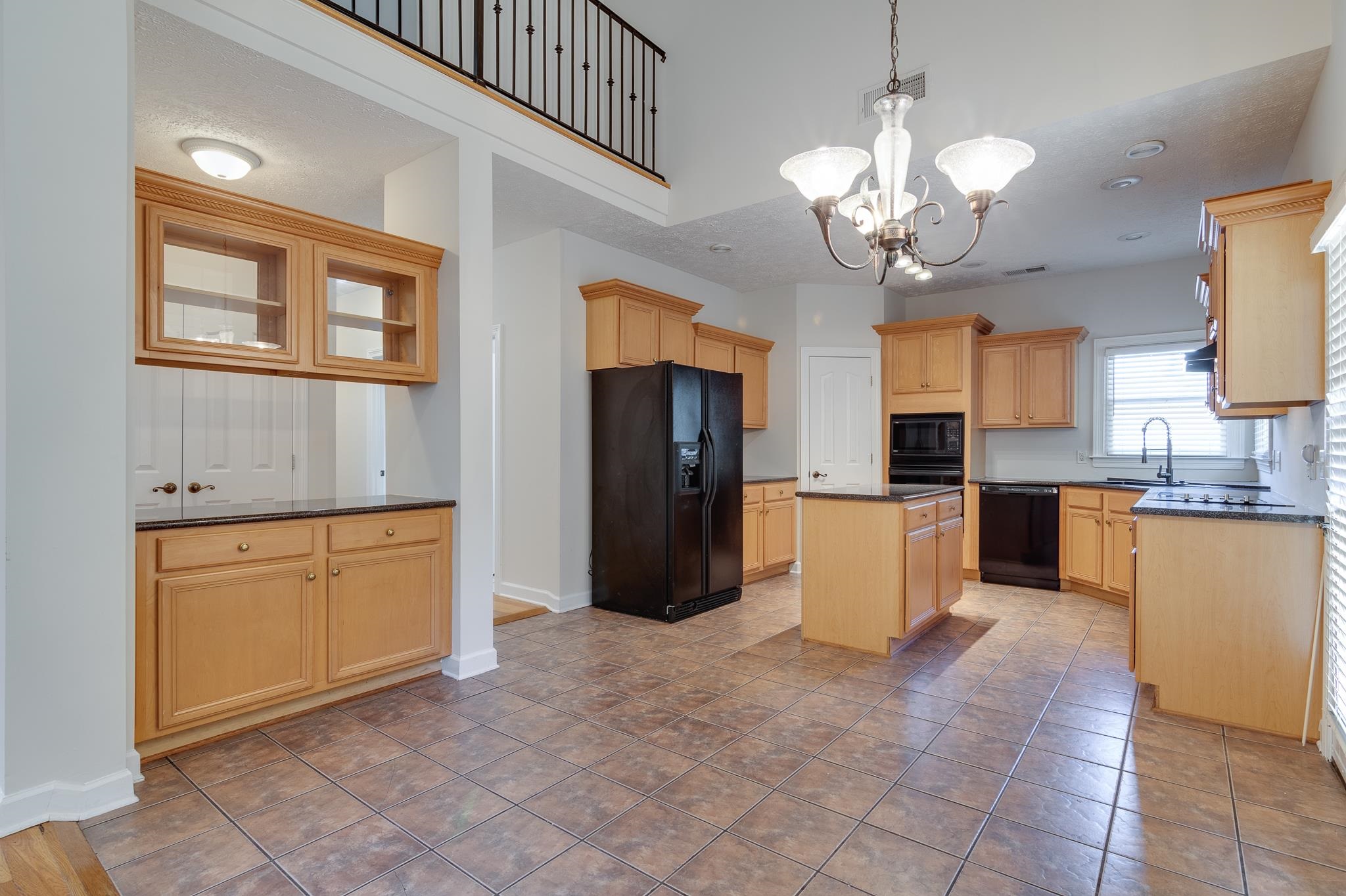 4306 Wind Tree Cove Bartlett, TN 38135 - Photo 9 of 28 a large kitchen with stainless steel appliances kitchen island granite countertop a refrigerator a stove a sink dishwasher with a dining table and chairs
