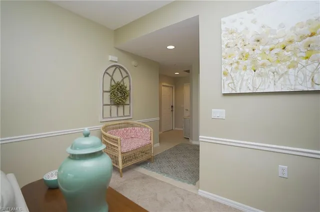 a hallway with painting on the wall and a large mirror