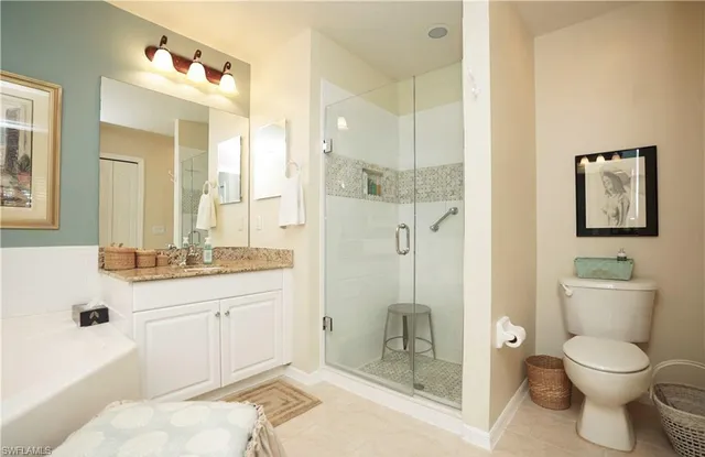 a bathroom with a granite countertop sink toilet and shower