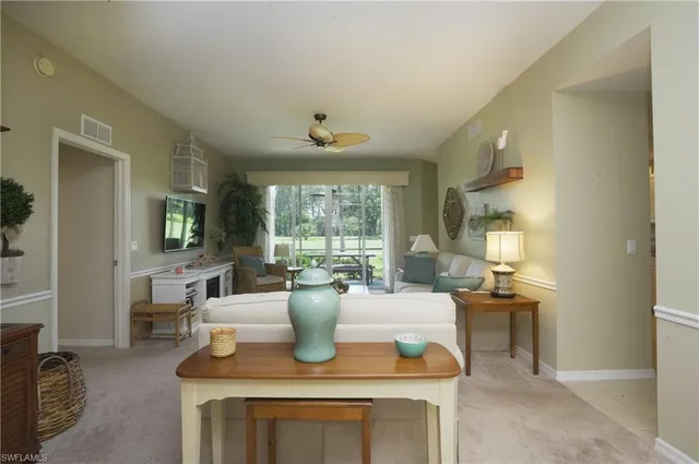 a living room with furniture a large window and a chandelier