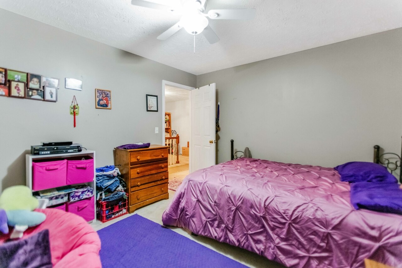 1512 Oak Ridge Court Hopkinsville, KY 42240 - Photo 18 of 24 a bedroom with a bed and a chandelier