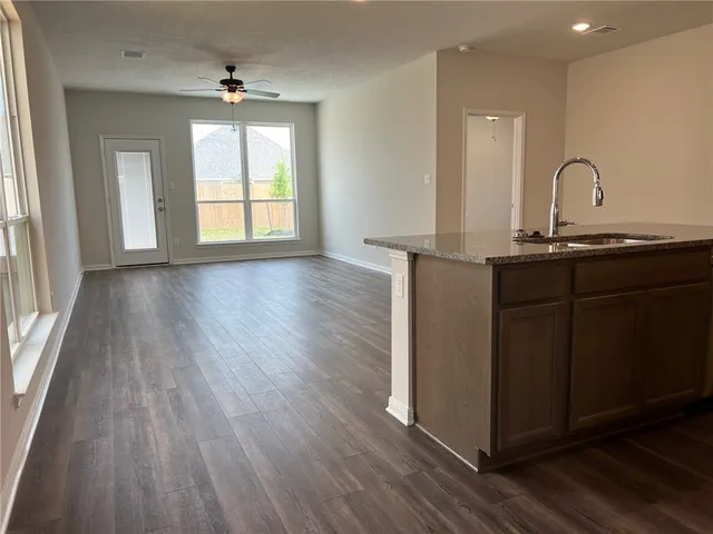 a kitchen with sink a window and wooden floor