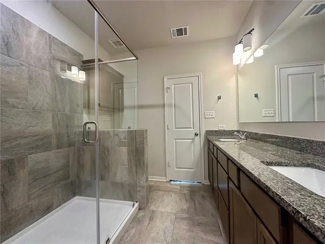 a bathroom with a granite countertop sink a mirror and a bathtub